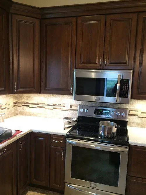 Kitchen with cherry cabinets, stainless appliances and a tile backsplash