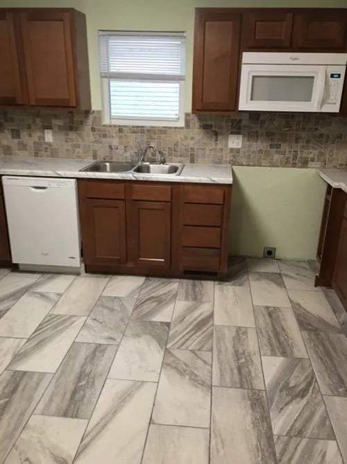 Kitchen with wood cabinets and a large-format tile floor