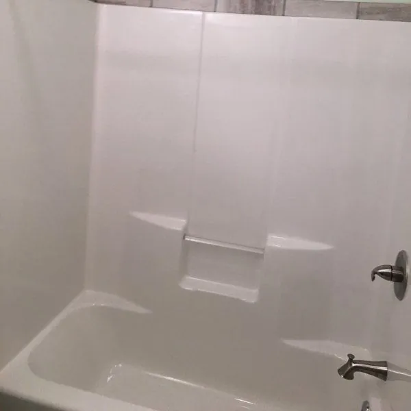 White tub and shower surround with brushed-nickel fixtures